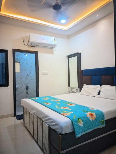a bedroom with a bed with a blue blanket on it at Hotel Moad Mudgal Palace in Godarpura