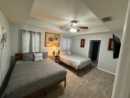 a bedroom with two beds and a ceiling fan at Spacious 3BR Home Sleeps 12 Near Valdosta in Hahira