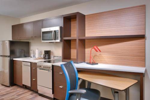 a kitchen with wooden cabinets and a table and chairs at TownePlace Suites by Marriott Salt Lake City Draper in Draper