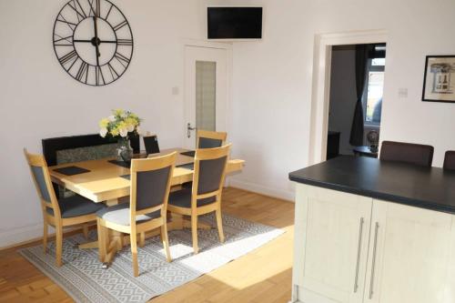 a dining room with a table and chairs and a clock at The Coach House - 1 mile from Beamish Museum in Beamish