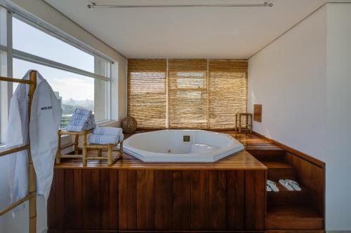 a large bath tub in a room with a window at Park Inn by Radisson Berrini in Sao Paulo