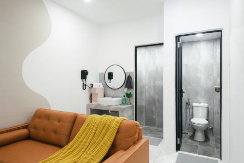 een woonkamer met een bruine bank en een spiegel bij Cameron Centrum Family Haven Kids Playground Clover Home A-3-15A in Brinchang