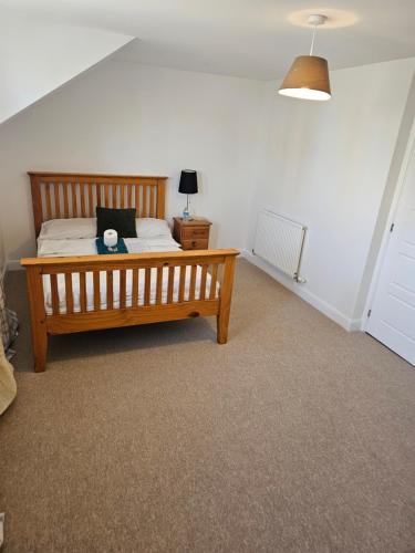 a bedroom with a wooden bed and a lamp at Very Large King bedroom- Dartford Central in Dartford