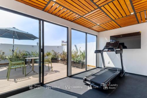 a room with a treadmill and a patio with a table at Magis Downtown Juarez by Capitalia in Mexico City