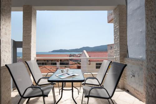 a patio with a table and chairs on a balcony at BLUE HORIZON SARTI Oe in Sarti