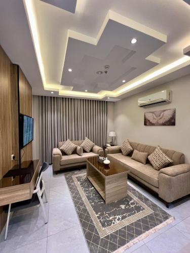 a living room with two couches and a tv at فندق ميلان بارك 2 -إحدي مجموعة ميلان بارك للفنادق in Taif
