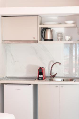 a kitchen with white cabinets and a sink at BLUE HORIZON SARTI Oe in Sarti