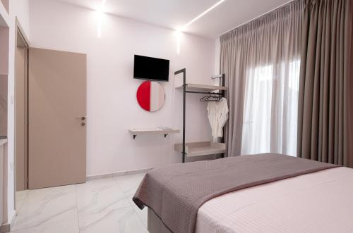 a bedroom with a bed and a tv and a window at BLUE HORIZON SARTI Oe in Sarti