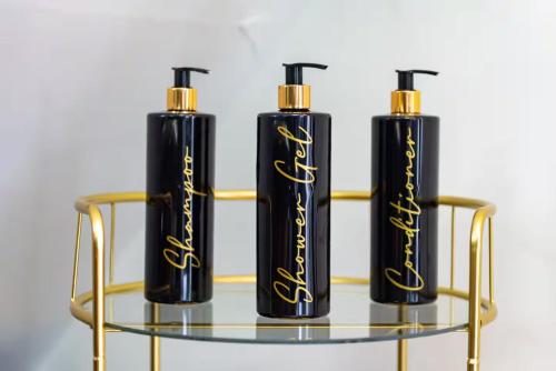 three black and gold candles on a glass shelf at Castle Queen in Coseley