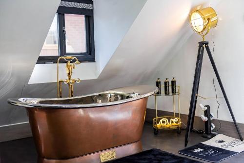 a large copper tub in a room with a lamp at Castle Queen in Coseley