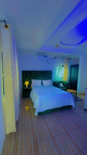 a bedroom with a white bed and a blue light at Abu Dhabi CC Hotel in Limbe