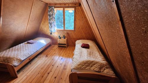 two beds in a small room with a window at Chata u Hagrida in Štrba