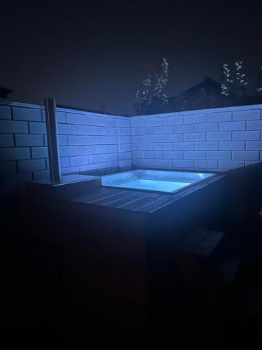 a hot tub in a brick wall at night at Vila Family in Poprad