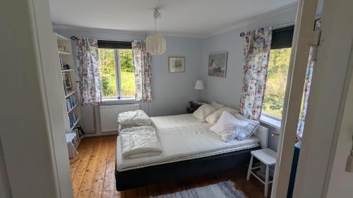 a small bedroom with a bed and two windows at Beautiful Idhult 2 in Aneby