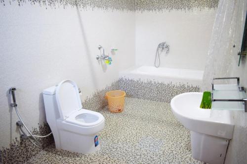 a bathroom with a toilet and a sink and a tub at Semni Escape Plantation Bungalow-Vagamon in Vagamon