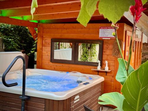 una bañera de hidromasaje en una casa de madera en Pension Nest - Family Apartman, en Mosonmagyaróvár