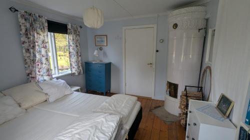 a bedroom with a white bed and a blue cabinet at Beautiful Idhult 2 in Aneby