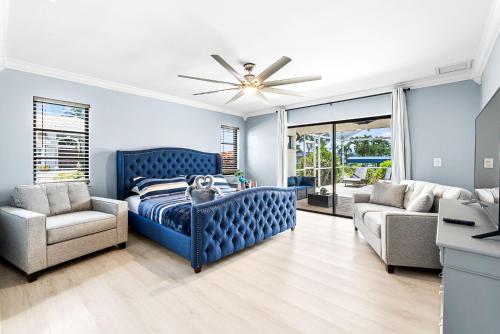 - une chambre avec un lit bleu et un canapé dans l'établissement Gorgeous Direct Sailboat Access home with solar heated pool - Villa Linda, à Cape Coral