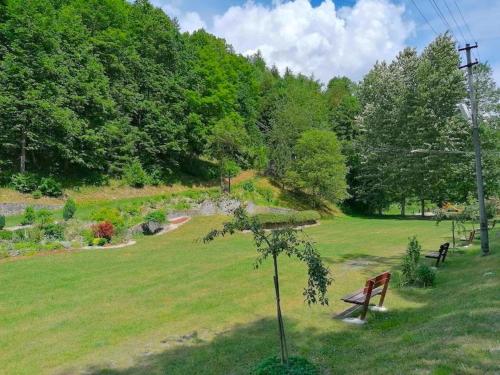 a park with two benches in a green field at Dvojizbový Útulný Apartmán Oščadnica in Oščadnica