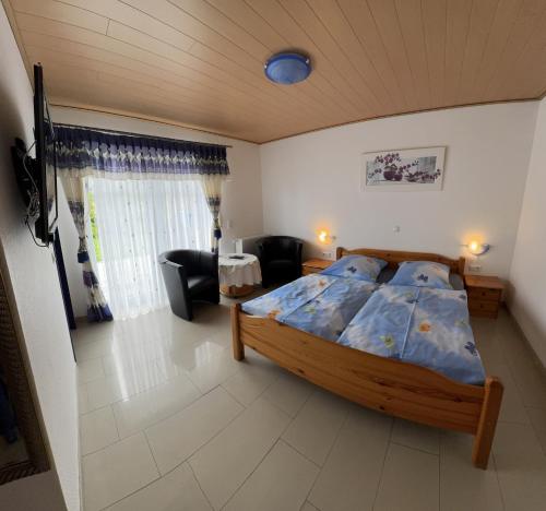 Un dormitorio con una cama y una sala de estar. en Pension Cecilia, en Norddeich