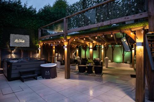 a patio with a wooden pergola and a grill at Castle Queen in Coseley