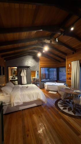 a large bedroom with a large bed and a table at Vila Chamonix - Chalé Cabernet in Urubici