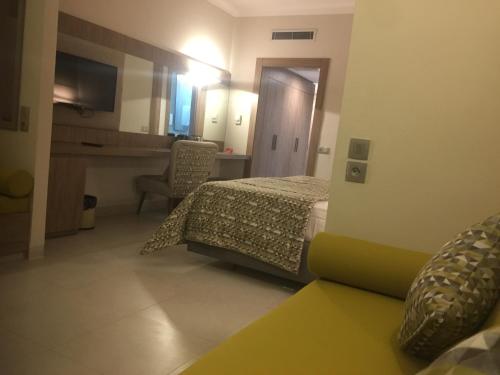 a hotel room with a bed and a desk and a computer at Hotel La Residence Hammamet in Hammamet