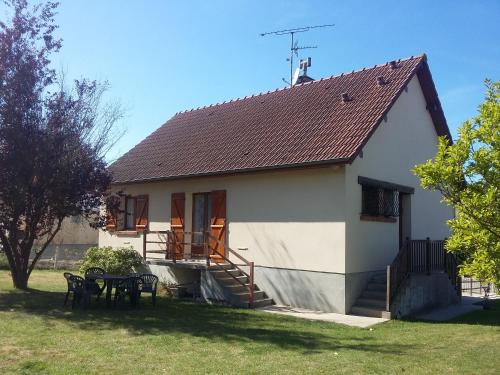 a small white house with a table and chairs at La Maison Trèfle in Vieux-Rouen-sur-Bresle