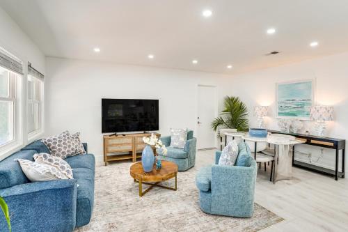 a living room with blue couches and a piano at 7 Mi Huntington Beach Family Home with Patio! in Midway City