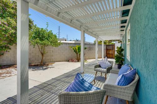 a patio with wicker chairs and a white pergola at 7 Mi Huntington Beach Family Home with Patio! in Midway City