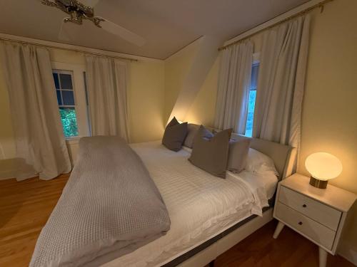 a bedroom with a bed with white sheets and pillows at 3 bedroom home next to downtown and medical mile in Grand Rapids