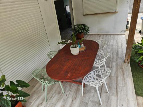 a wooden table and chairs with plants on a patio at Chambre a 6 minutes de l'aéroport in Les Abymes