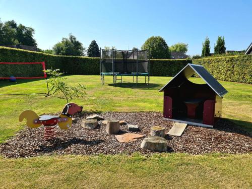 a play area with a dog house and a playground at B&B het Zandoogje in Hollandscheveld