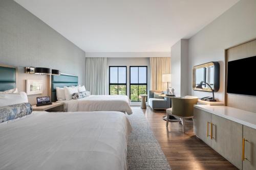 a hotel room with two beds and a flat screen tv at Hotel Effie Sandestin Resort, Autograph Collection in Destin