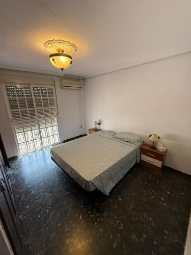 Un dormitorio con una cama y una ventana grande. en Family house, en Sevilla