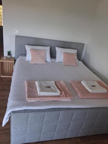 a bed with pink towels and pillows on it at Vineyard cottage foggy sea in Semič