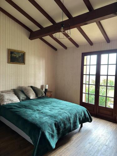 a bedroom with a large bed and a large window at Propriété de charme avec vue panoramique in Mongauzy