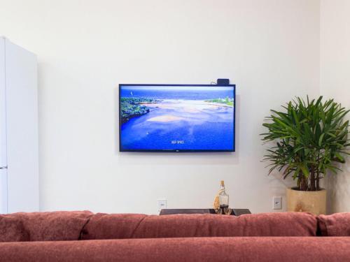 Una televisión o centro de entretenimiento en Casa com 2 quartos em condomínio tranquilo, suíte com cama king, ar-condicionado, Wi-Fi rápido, cozinha equipada e garagem privativa