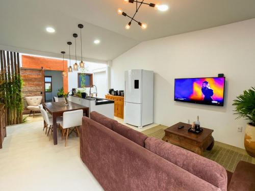 Una televisión o centro de entretenimiento en Casa com 2 quartos em condomínio tranquilo, suíte com cama king, ar-condicionado, Wi-Fi rápido, cozinha equipada e garagem privativa