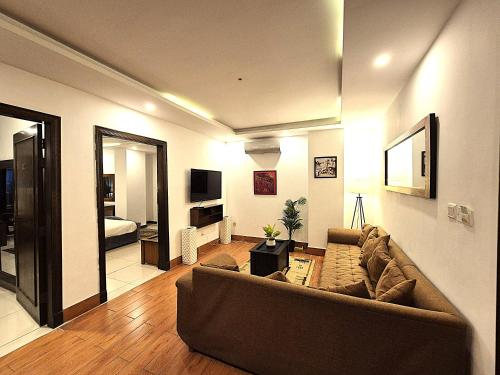 a living room with a couch and a bedroom at The Grandview Manor - 2 Bed Luxury Apartment with City Views in Rawalpindi
