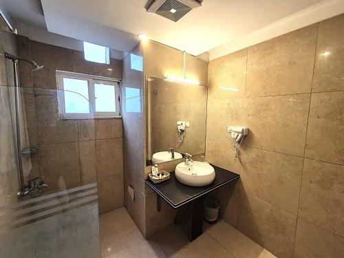 a bathroom with a sink and a shower at The Grandview Manor - 2 Bed Luxury Apartment with City Views in Rawalpindi