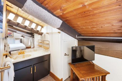a bathroom with a sink and a tv in a room at Crestwood 3305 Deluxe 1 Bedroom Plus Loft in Snowmass Village