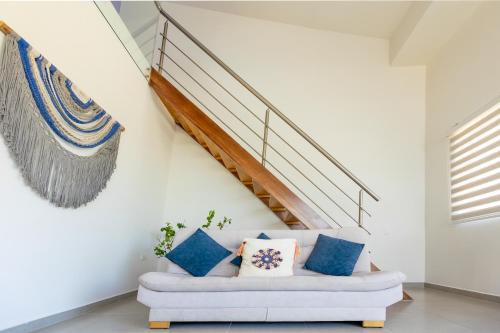 a living room with a white couch and stairs at Dúplex de lujo con vista al mar - San Bernardo del Viento in San Bernardo del Viento