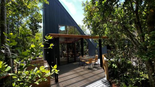 a small house with a deck in the woods at Inspiramide Pucon in Pucón