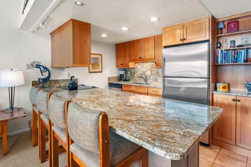 a kitchen with a granite counter top and a refrigerator at Crestwood 3310 Standard 1 Bedroom Plus Loft in Snowmass Village
