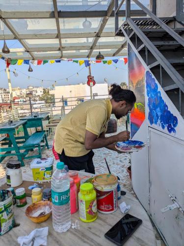 a man preparing a plate of food on a table at Whereabout Hostel Udaipur in Udaipur
