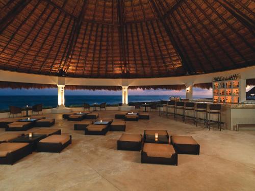 a resort lobby with tables and chairs and the ocean at Hard Rock Hotel Riviera Maya - Heaven Adults Only - All Inclusive in Puerto Aventuras