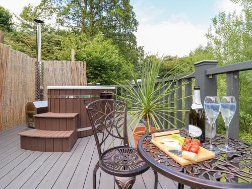 a patio with a table and chairs on a deck at Red Kite at Wild Valley Huts in Oswestry