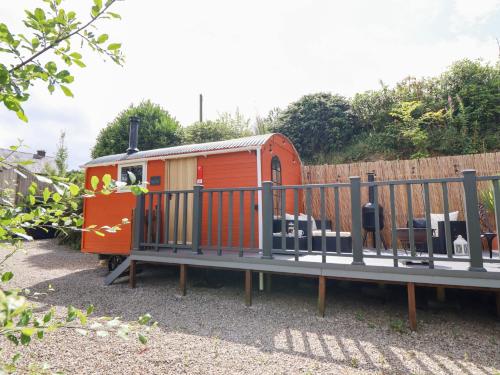 a toy train is parked next to a fence at Red Kite at Wild Valley Huts in Oswestry