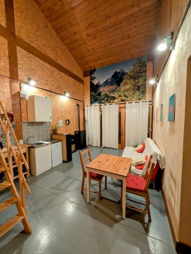 a room with a table and chairs and a kitchen at la caseta viva in Olvan